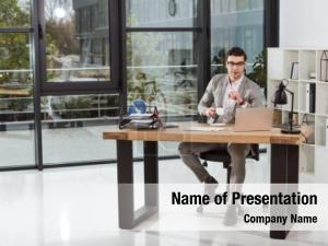 Manager is working at Office Desk PowerPoint Template