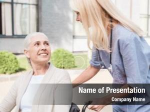 Smiling nurse looking disabled woman PowerPoint Template