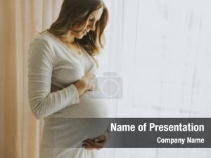Pregnant portrait young woman window