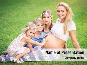 Mother of many children, cute blond pregnant woman with her three older children with pleasure spending time outdoors, happy family life