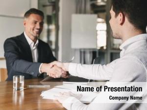 Business, career and placement concept - successful young man smiling and handshaking with european businessman after successful negotiations or interview in office