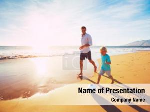 Happy Father and Son Having Fun Playing Soccer on the Beach at Sunset