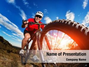 Low angle view of cyclist riding mountain bike on rocky trail at sunrise