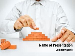 Concept of building and construction, hand put the last brick on the wall -Businessman hand placing a brick on a wall