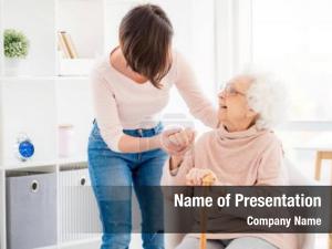 Kind woman helping lovely old lady to stand from chair