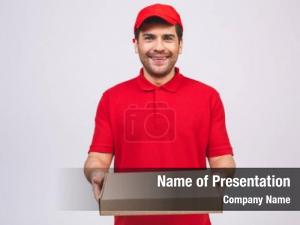  of a happy young delivery man in red cap standing with parcel post box  over white 