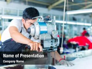 Indonesian worker using a cutter - a large machine for cutting fabrics - in a asian textile factory, he wears a chain glove