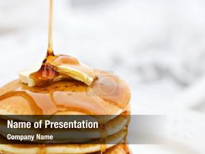 Pouring maple syrup onto pancakes